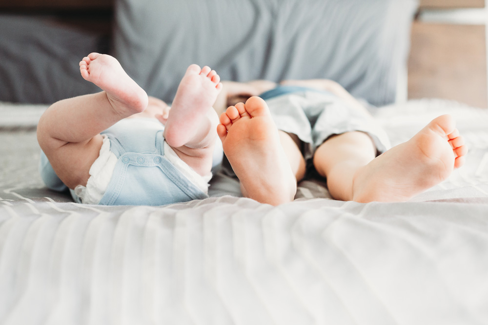 siblings feet and toes in bed