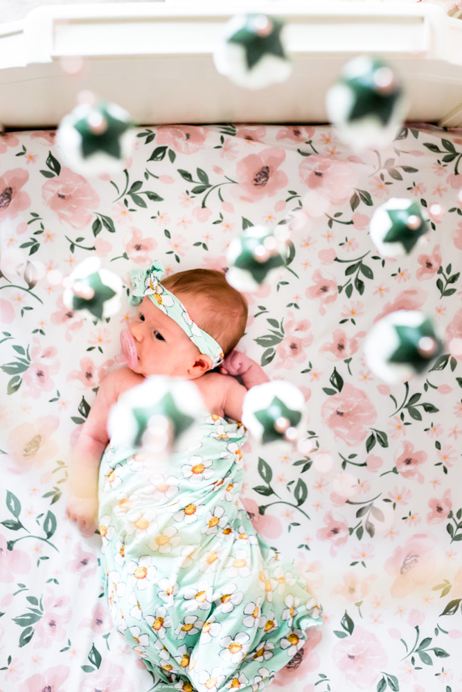 DFW newborn baby in nursery with pink rose crib