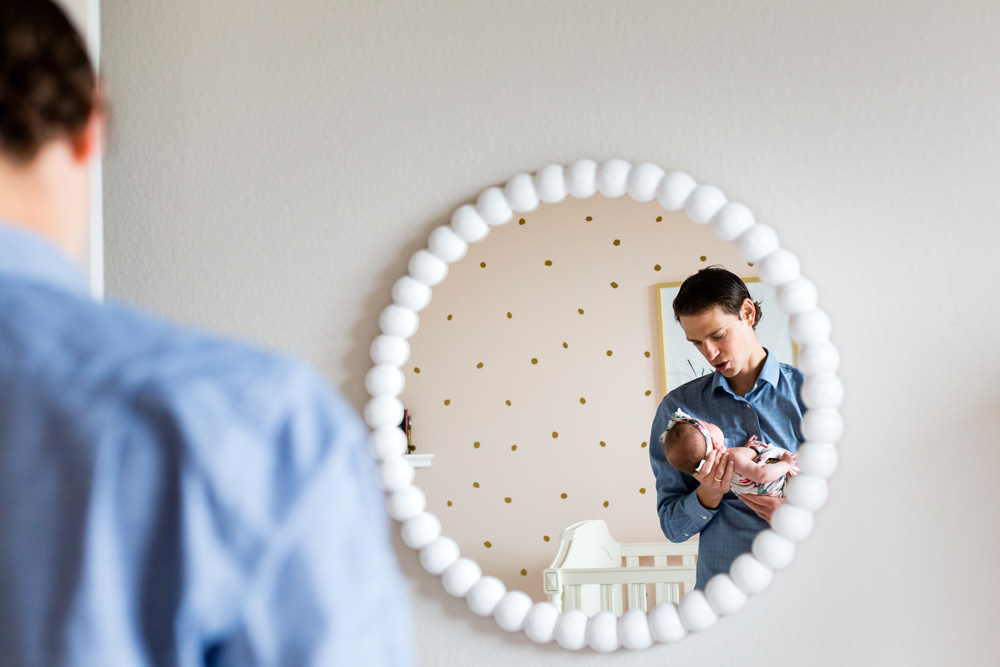 Father holding baby looking in mirror Dallas lifestyle newborn photo